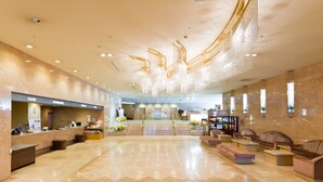 A spacious lobby with a reception desk, seating areas, and a staircase leading to upper floors. - Niigata Grand Hotel (Niigata)
