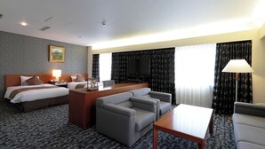 A hotel room with two beds, a sofa, a TV, and a desk with a lamp. - Yamagata Grand Hotel (Yamagata)