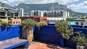 A rooftop terrace with a view of a mountain and cityscape. - La Rose B&B (Cape Town)