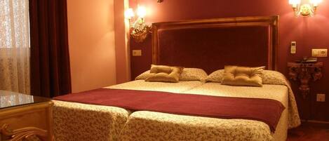 A hotel room with a large bed, two bedside tables, and a nightstand.