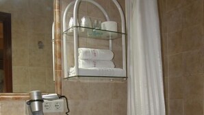 A bathroom with a toilet, sink, and shower area. - Goya Suites (Salamanca)