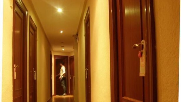 A hotel hallway with wooden doors and a wooden floor. - Goya Suites (Salamanca)