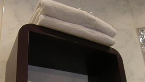 A brown box containing two white towels with red text. - Goya Suites (Salamanca)