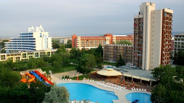 A hotel with a large swimming pool, a water slide, and multiple buildings with balconies. - Iskar (Nessebar)