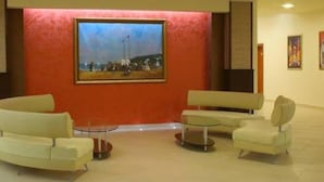 A lobby with a large painting, two sofas, and a small table. - Iskar (Nessebar)