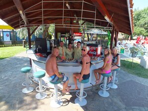 A bar area with stools and a counter, surrounded by a wooden structure. - Iskar (Nessebar)