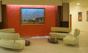 A lobby with a large painting, two sofas, and a small table. - Iskar (Nessebar)