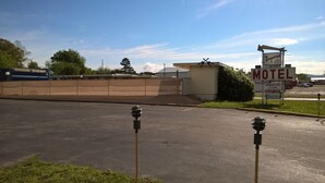 A motel with a sign indicating vacancy and amenities including an American clean internet pool, refrigerated coffee, and musicians. - Dogwood Motel (Mountain View)