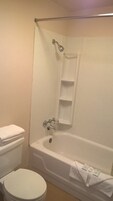 Un baño con bañera, inodoro y cortina de ducha.
