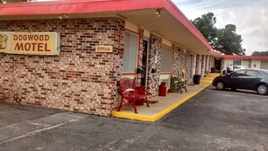 A brick motel with a red awning, a sign reading "DOGWOOD MOTEL," and a single red bench outside. - Dogwood Motel (Mountain View)
