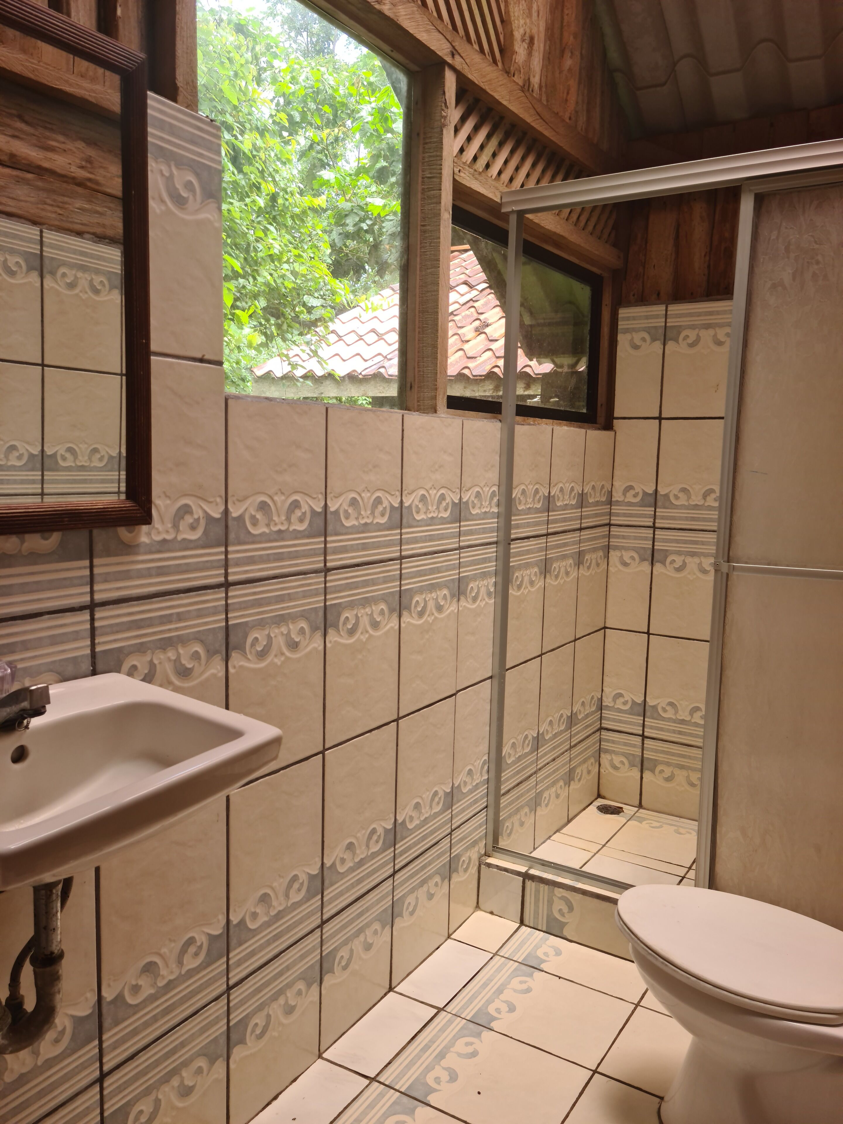 A bathroom with a sink, toilet, and shower area.