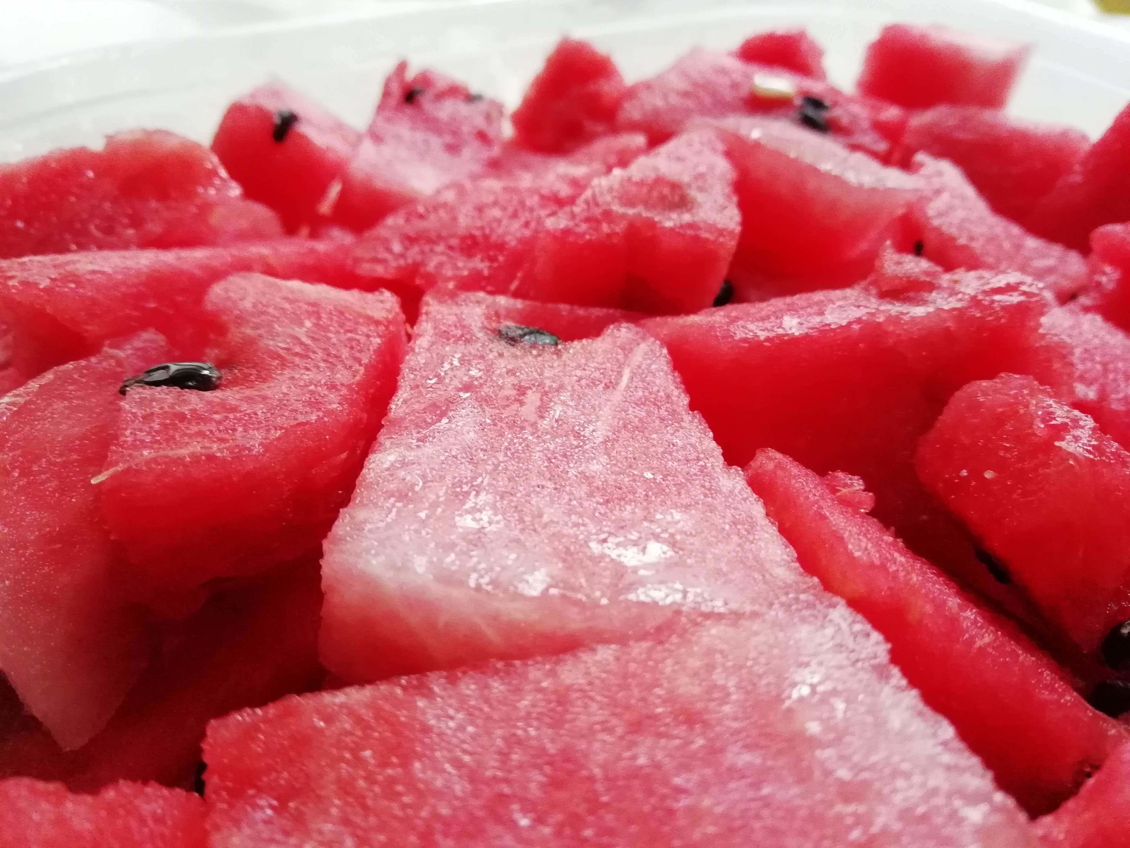 A close-up of red watermelon cubes with a white background.