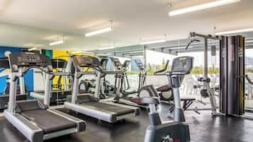 Uma academia com esteiras, elípticos e equipamentos de musculação.