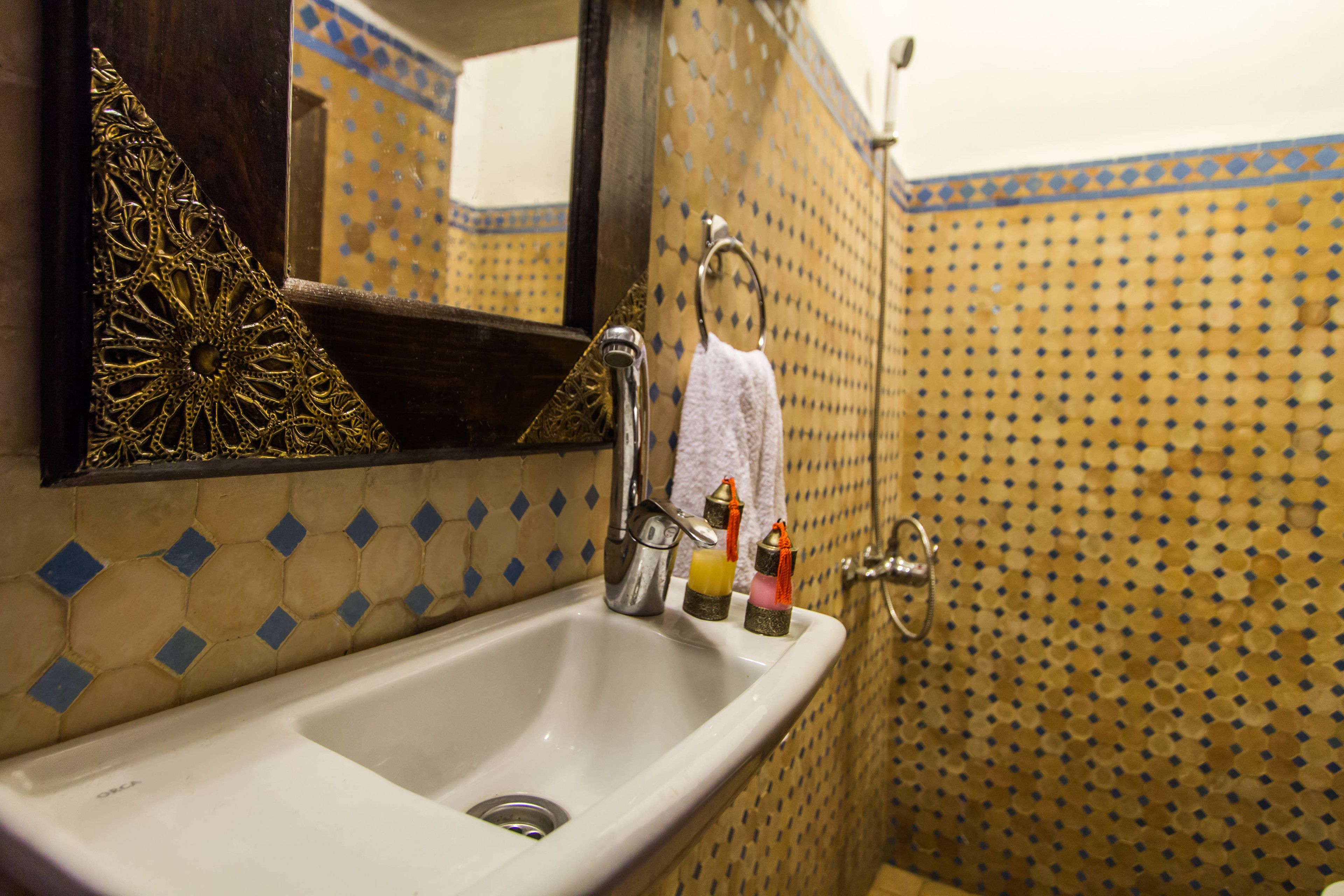 A bathroom with a sink, mirror, and tiled walls.