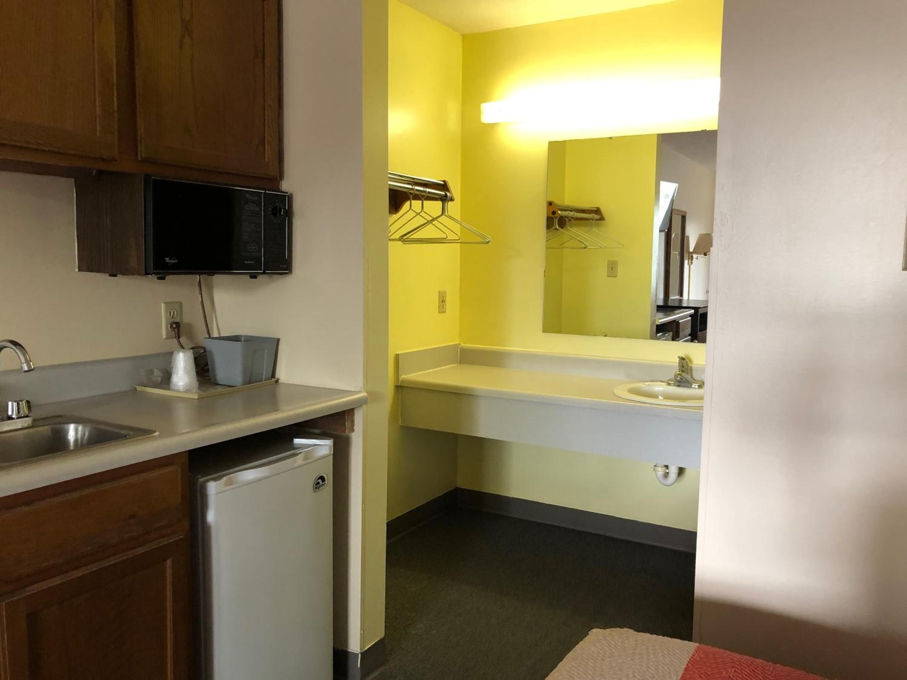 A compact kitchen with a sink, a microwave, and a small refrigerator.