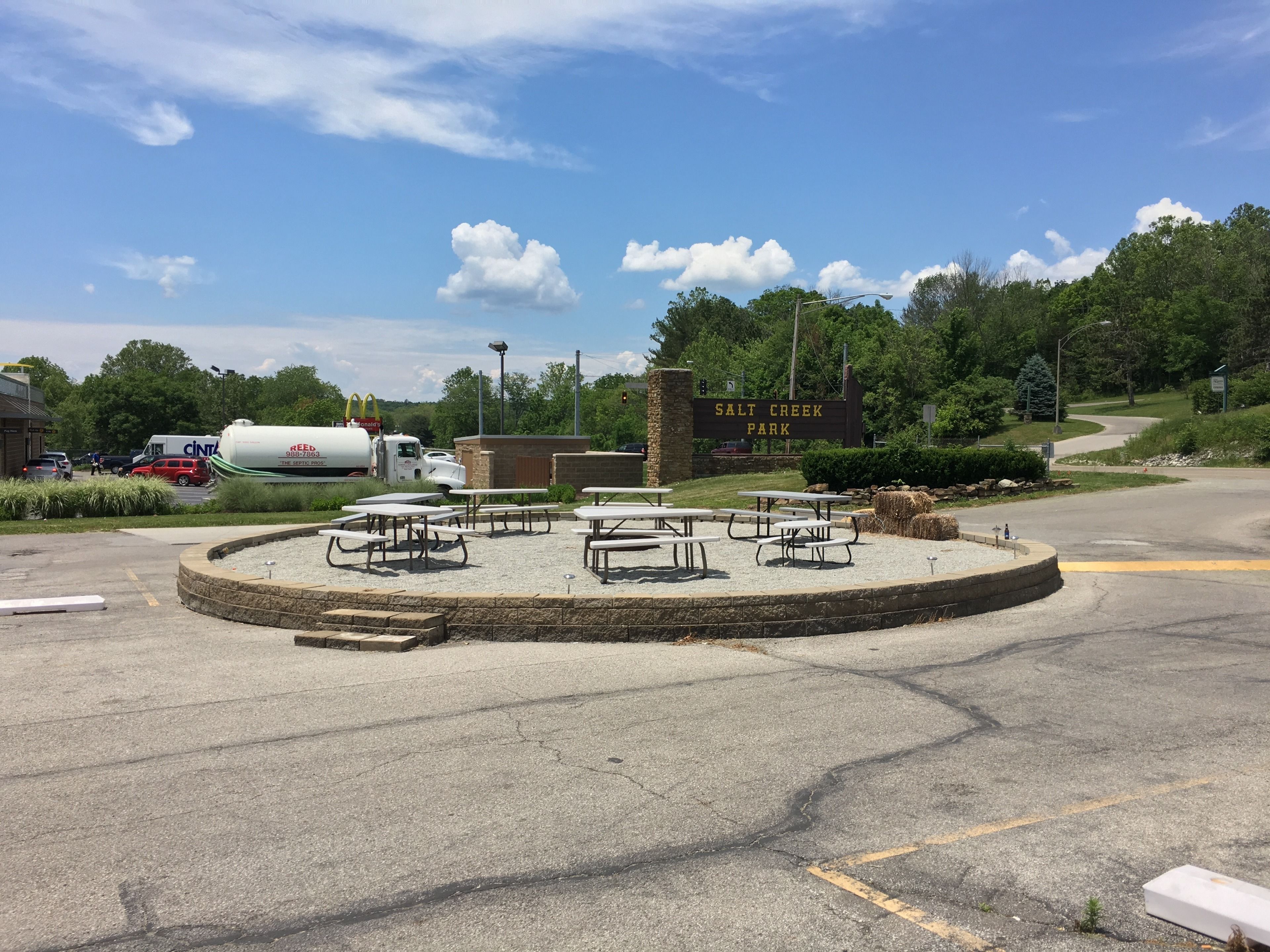 A parking area with picnic tables and a sign for Salt Creek Park.