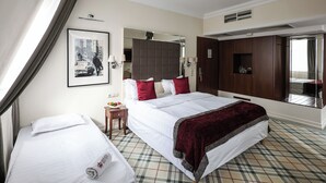 A hotel room with a large bed, a smaller bed, a wardrobe, a mirror, a bedside table, and a framed picture on the wall. - Mirage Medic Hotel (Budapest)