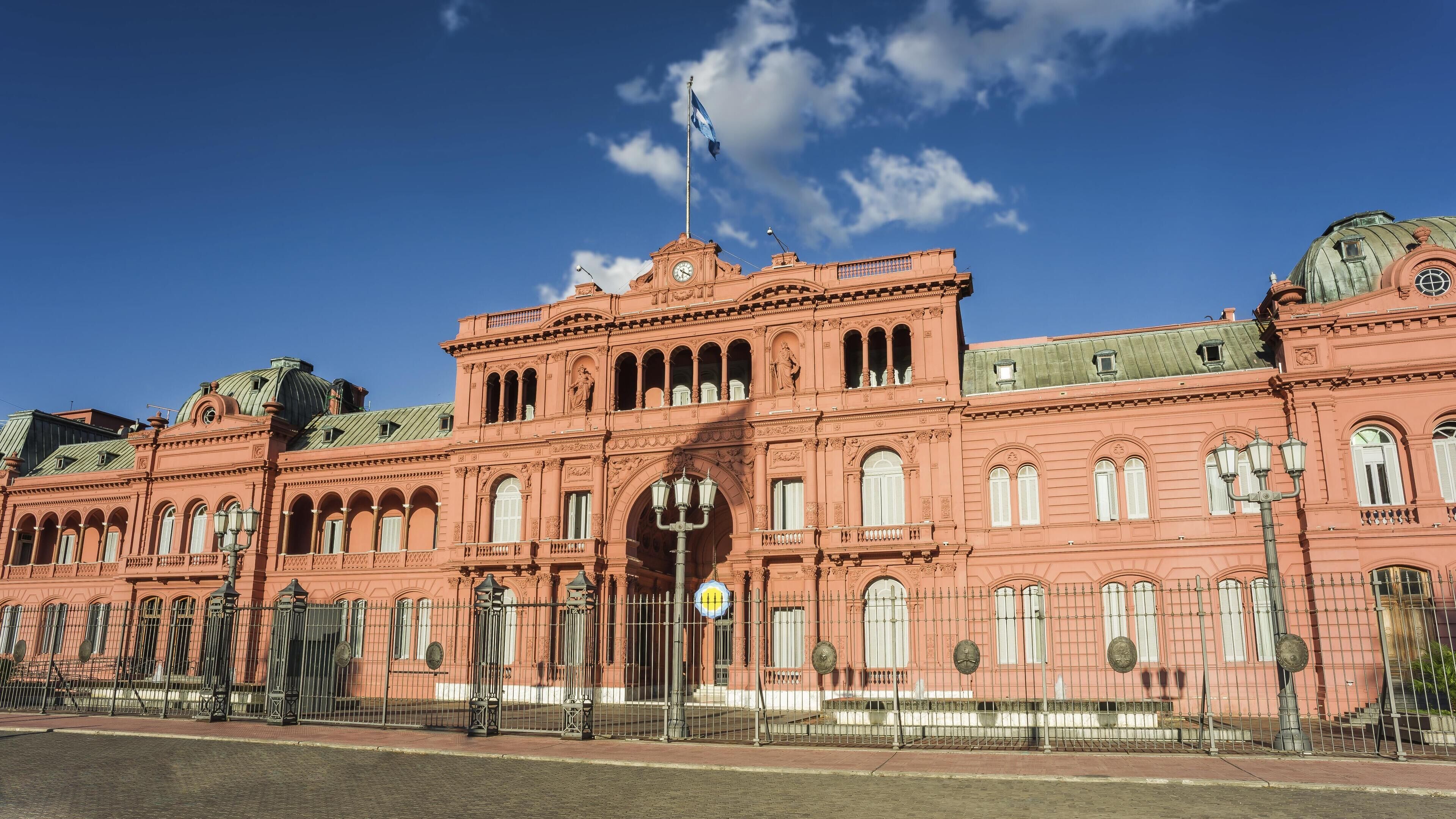 Un grande edificio storico con una torre dell'orologio ben visibile e finestre ad arco.