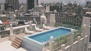 A rooftop pool with lounge chairs and a view of the cityscape, including a HSBC building. - NH Collection Buenos Aires Centro Histórico (Buenos Aires)