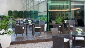 An outdoor seating area with wicker furniture and potted plants. - NH Collection Buenos Aires Centro Histórico (Buenos Aires)