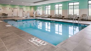 An indoor pool with no diving signs, a lifeguard chair, and a pool lift. - Hampton Inn & Suites Hudson (Hudson)