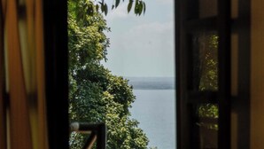 Ein Zimmer mit Blick auf ein Gewässer und viel Grün.