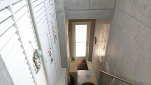 A narrow staircase with a handrail, leading to a door at the top. - Guest House Sea glass (Itoman)