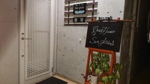 A hotel entrance with a sign reading "Guest House Sea Glass" and a welcome sign. - Guest House Sea glass (Itoman)