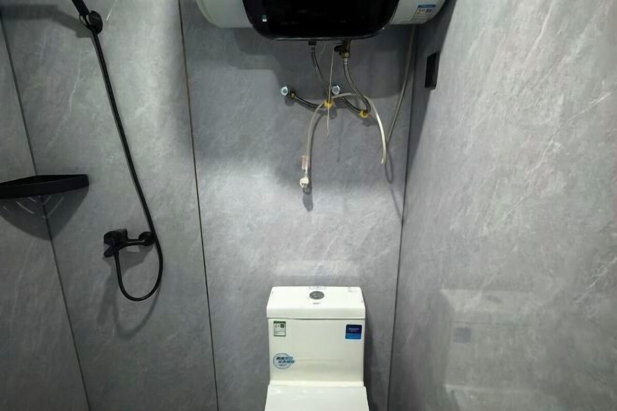 A bathroom with a toilet, a shower, and a sink.