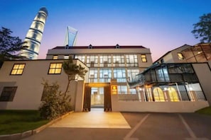A modern building with a prominent entrance, large windows, and a flag on top.
