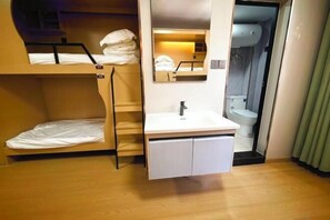 A compact hotel room with bunk beds, a small bathroom, and a sink. - Beehome Hostel (Shanghai)