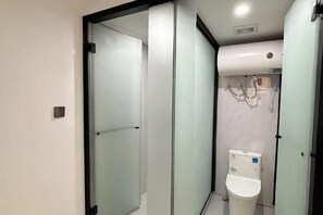 Un baño moderno con separador de vidrio, inodoro y zona de ducha.