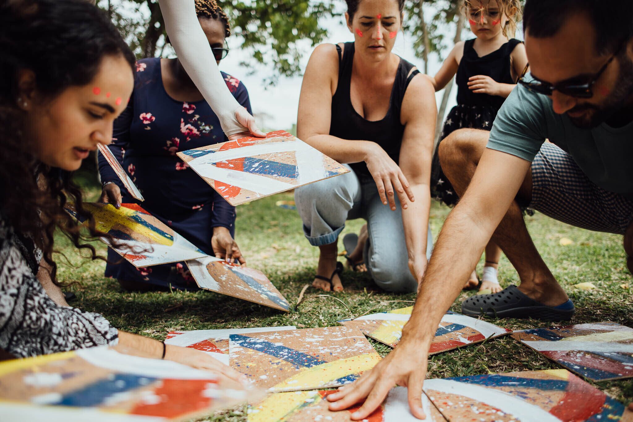 A group of people engaged in a collaborative activity on a grassy outdoor area.