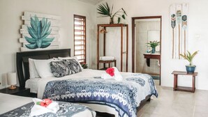 A hotel room with a bed, bedside table, and a mirror.