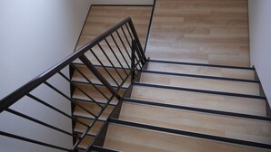 A staircase with wooden steps and black metal railings. - J-Hoppers Osaka Universal - Hostel (Osaka)