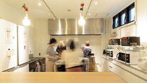 A modern kitchen with stainless steel appliances, wooden countertops, and hanging light fixtures. - J-Hoppers Osaka Universal - Hostel (Osaka)