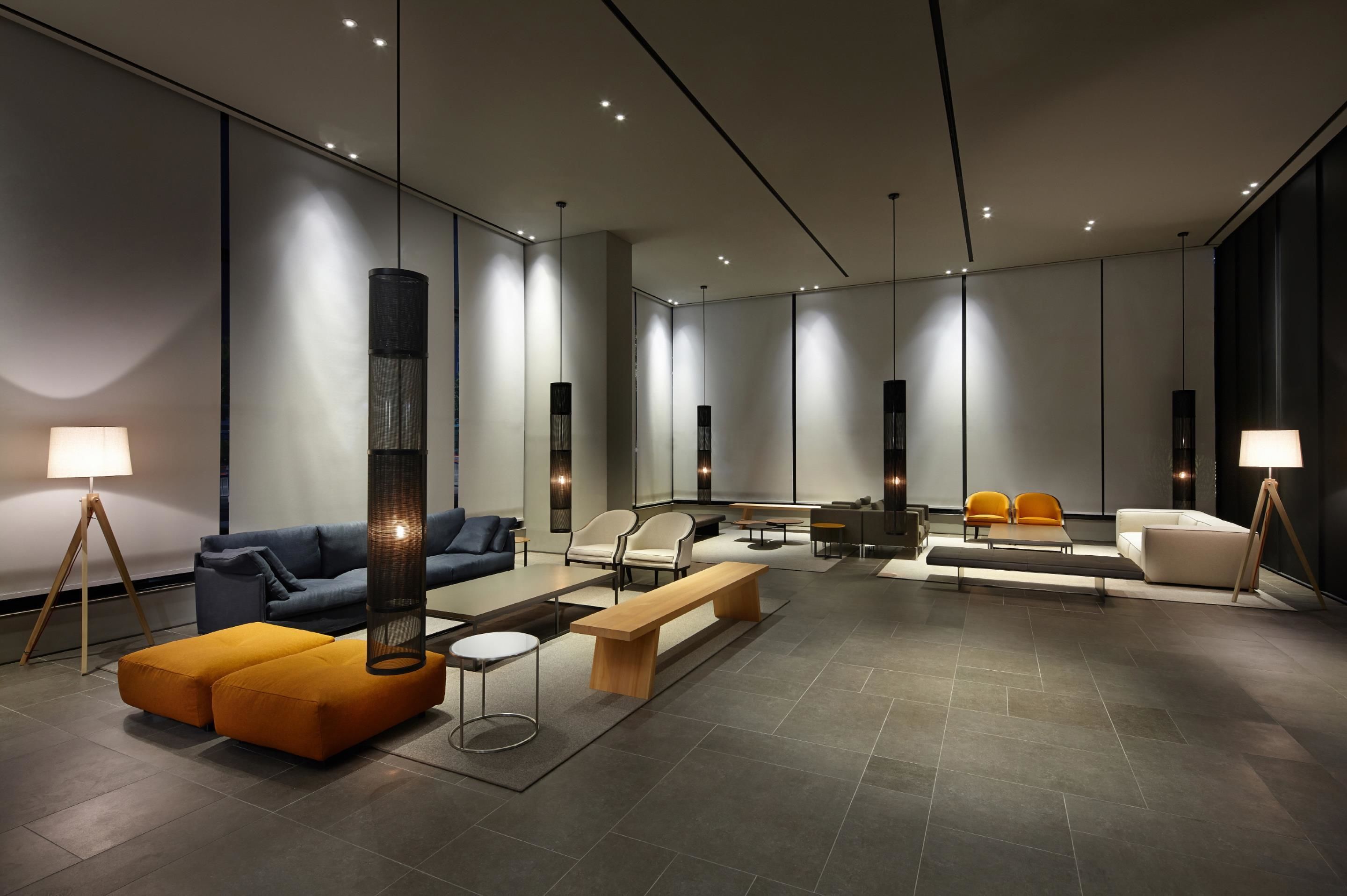 Un'area lounge moderna con divani, un tavolino da caffè e illuminazione a sospensione.