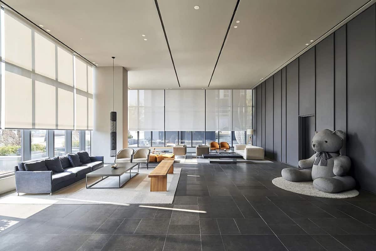 A spacious modern living area with a sofa, chairs, and a large window.