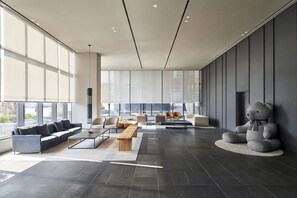 A spacious modern living area with a sofa, chairs, and a large window. - Shilla Stay Cheonan (Cheonan)
