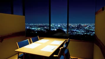 Enjoy a city view from the comfort of your room, with a large window framing the urban landscape and a wooden table for relaxation.