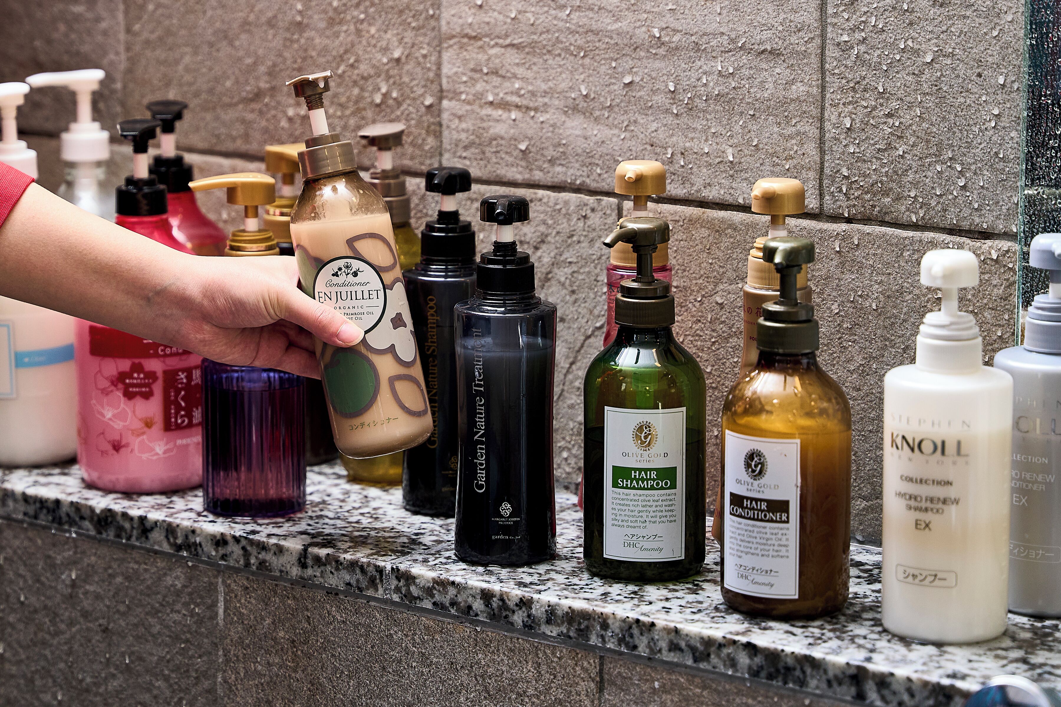 Une variété de produits de soins capillaires disposés sur un comptoir en marbre.