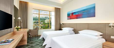 A hotel room with two beds, a desk, a TV, and a large window with a city view.
