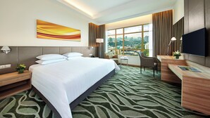A hotel room with a large bed, a desk, a chair, a TV, and a view of the city. - Sunway Lagoon Hotel (formerly Sunway Clio Hotel) (Petaling Jaya)