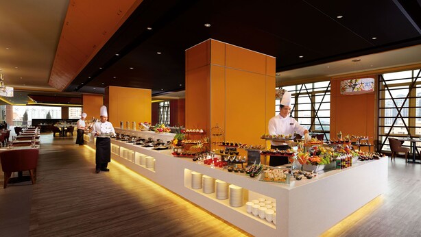 A modern buffet setup with chefs serving food, wooden flooring, and a view of the city through large windows. - Sunway Lagoon Hotel (formerly Sunway Clio Hotel) (Petaling Jaya)