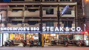 Een restaurant genaamd Smokin' Joe's BBQ Steak & Co. met terras en motorfietsen ervoor geparkeerd.