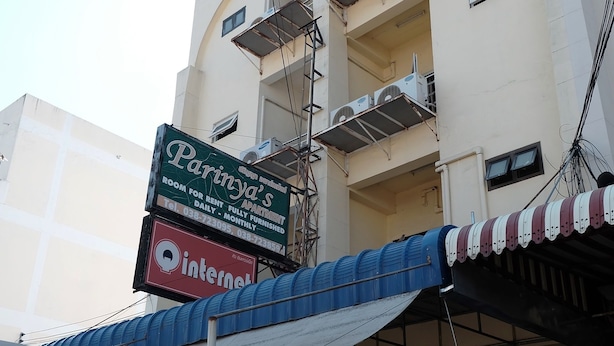 A multi-story building with a sign for Parinya's fully furnished apartment. - Parinya's Apartment (Pattaya)