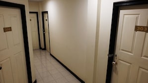 A corridor with doors numbered 306 and 303, leading to rooms. - Parinya's Apartment (Pattaya)