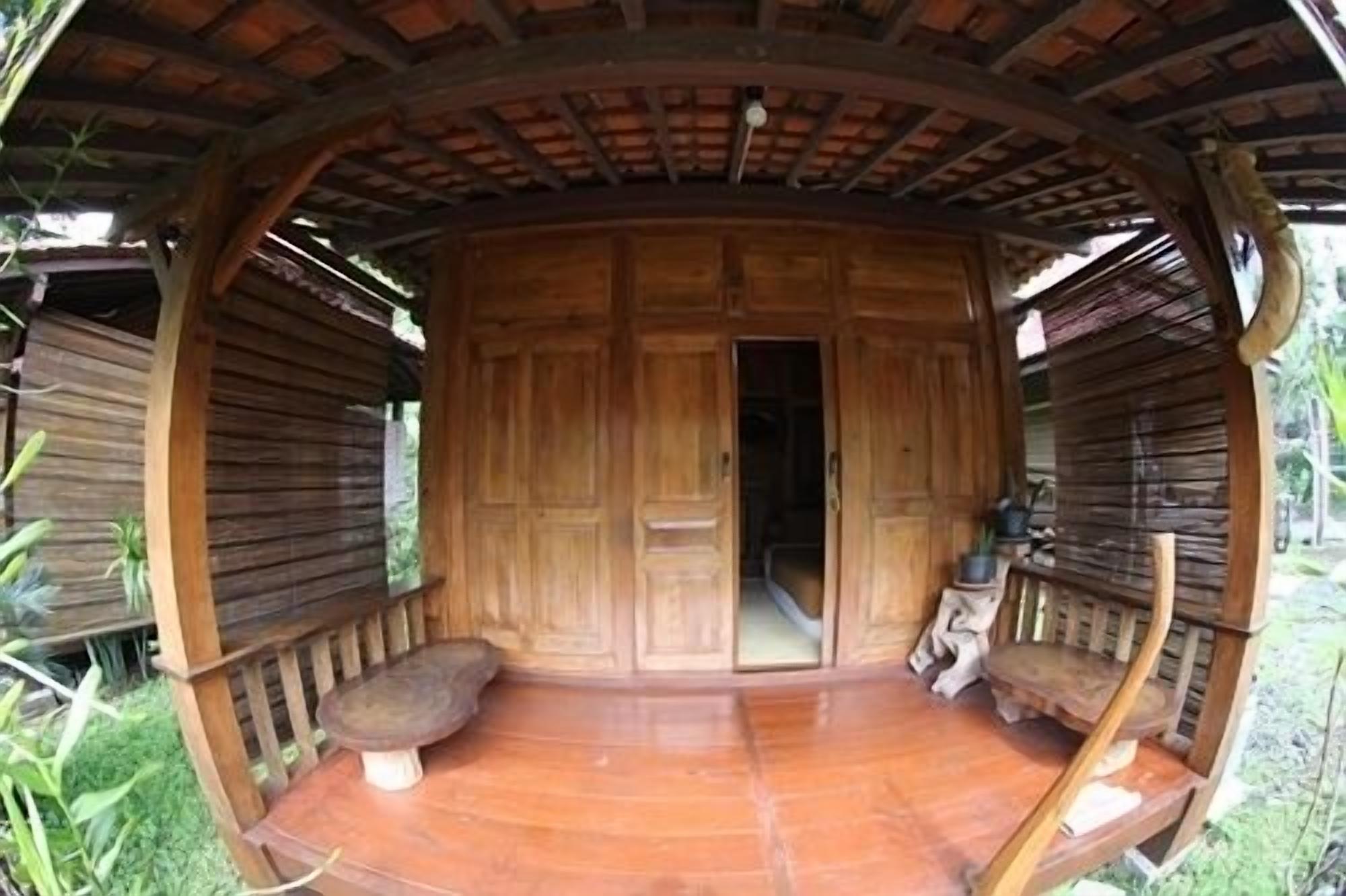 A wooden structure with a central door and benches on either side.