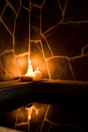 Una chimenea de piedra con tres velas.