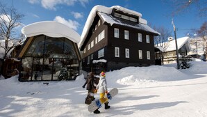 Een gebouw met een met sneeuw bedekte dak en een glazen structuur ernaast.